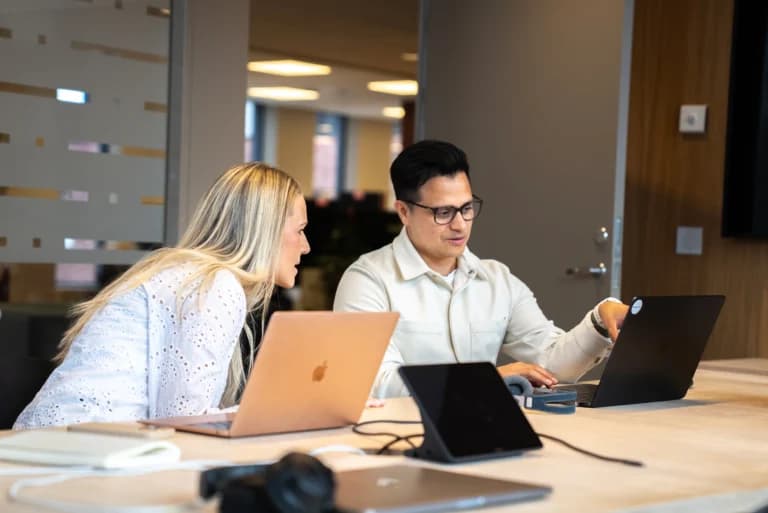 A photograph of our colleagues (Julia) and managing director (Hector) at Mediabooster Norway. In the photo, Hector and Julia are discussing plans for advertising, SEO and AI search for the coming period.